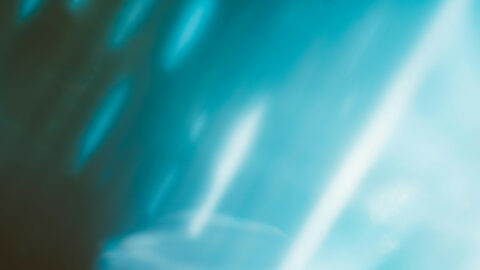 Abstraktes Bild mit blauen und weißen Lichtschlieren und verschwommenen Formen.