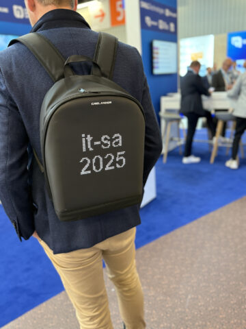 Person mit einem Rucksack, der auf einer Technologieveranstaltung oder -konferenz ausgestellt wird (2025).